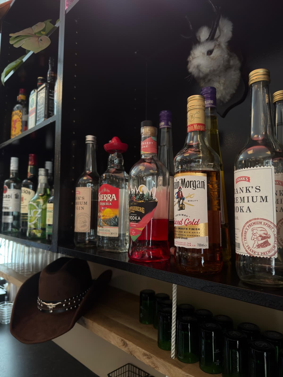 Barhyllan med flaskor och cowboyhatt